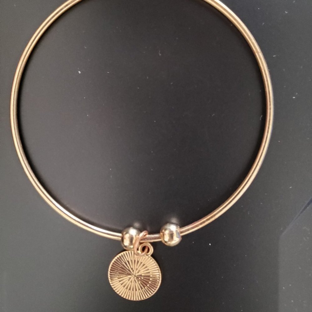 Gold Tone Bangle Bracelet with Two Beads and a Round Charm